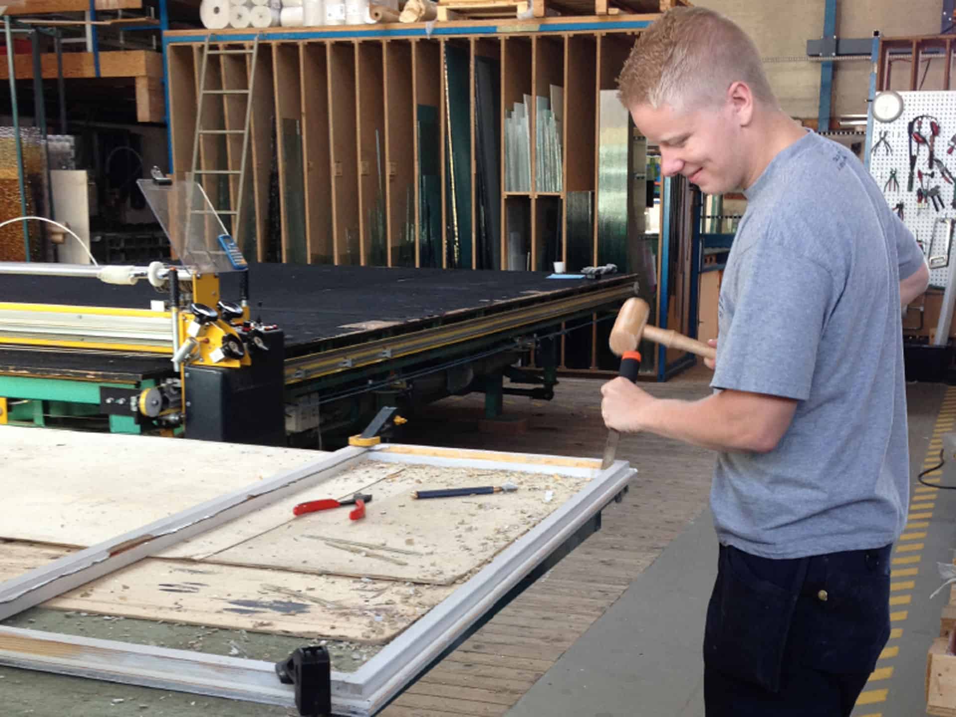 Glarmester på værksted bruger hammer og stemmejern